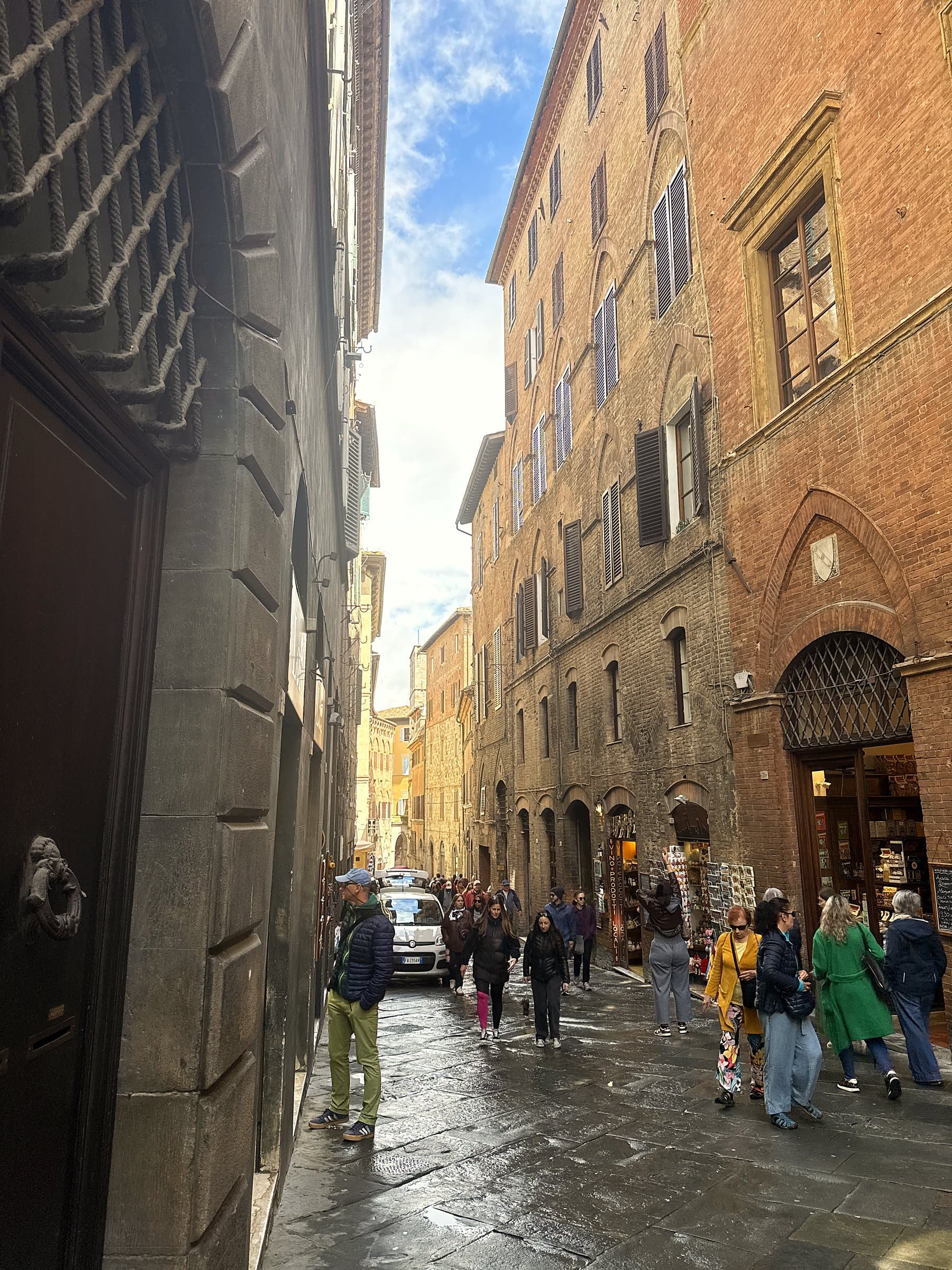 Historic brick street in Siena with shops and cafes