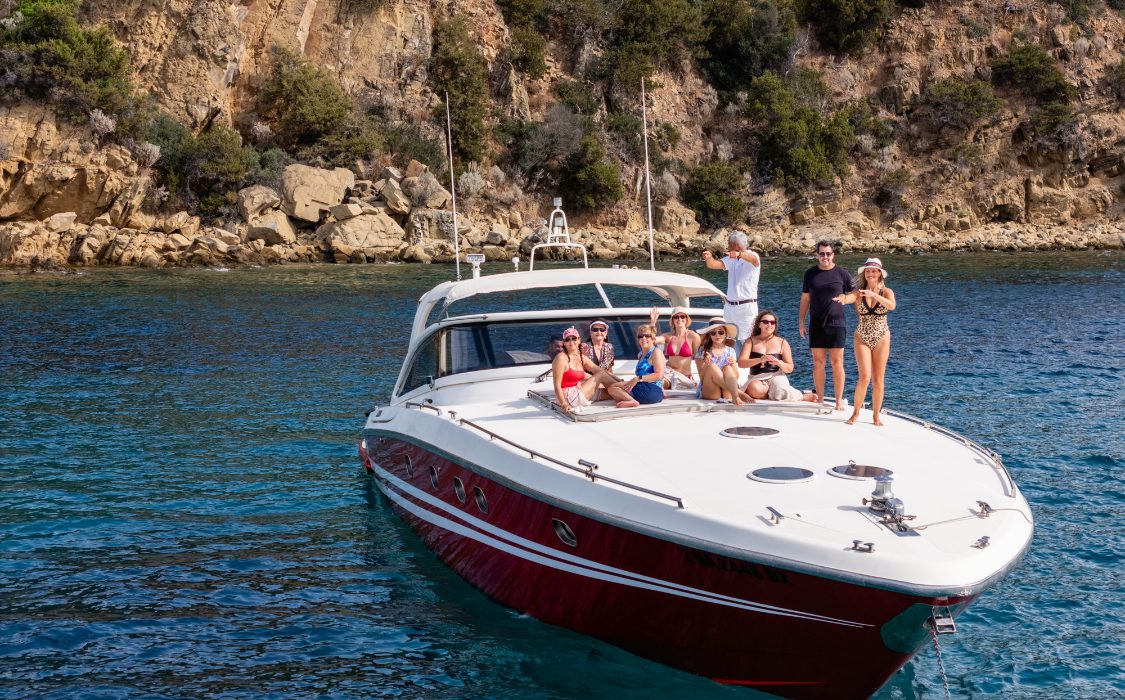 Erin and friends on a private boat anchored in a turquoise cove on the Tuscan coast